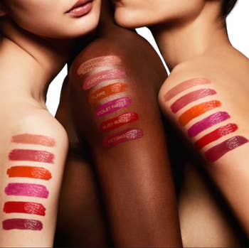 Three models with six different lipstick shade swatches on their shoulders
