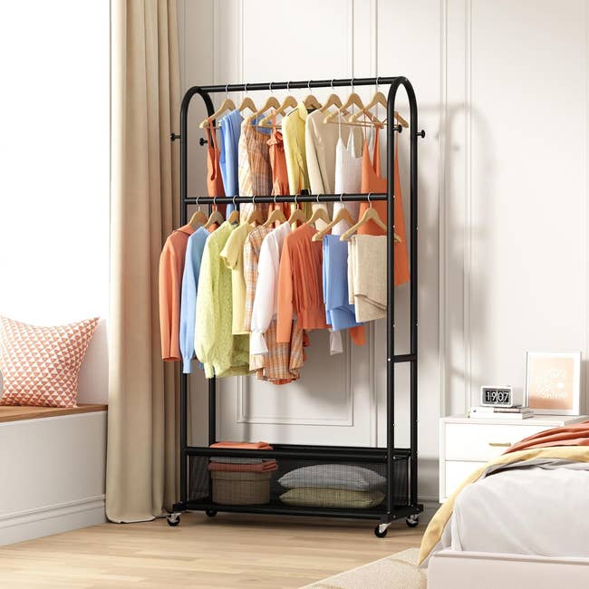 Clothing rack successful  a chamber  holds assorted  shirts and jackets, with a support  beneath  for pillows and baskets