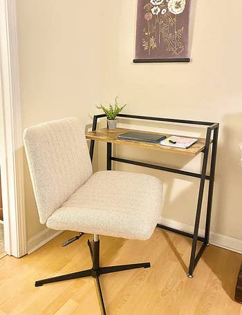 beige office chair with a rolling base styled next to a reviewer's desk