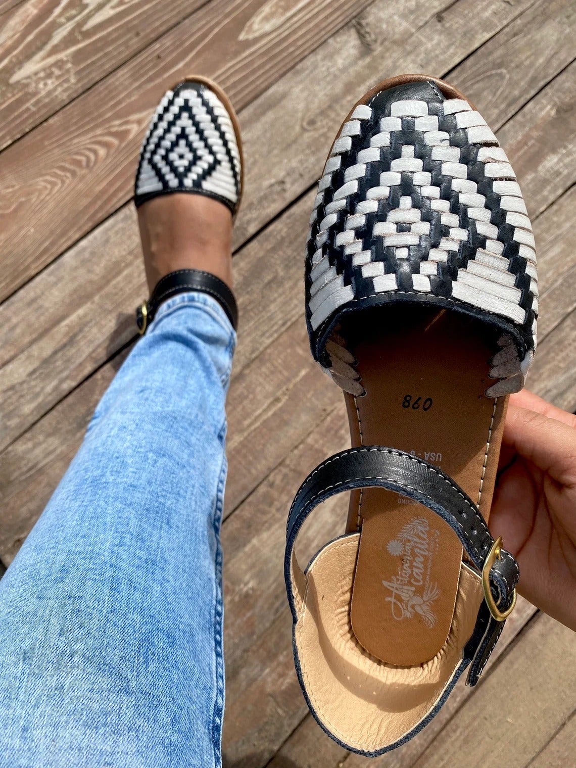 model holding the black and white braided shoe