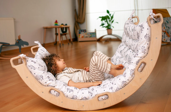 The set shown as a rocker with a cushion and a child laying on it