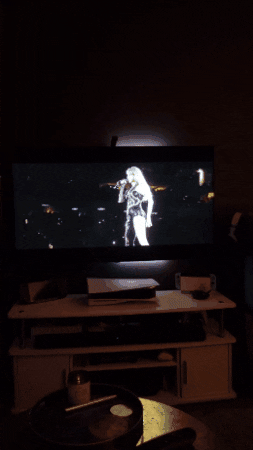 TV screen a clip of taylor swift eras tour with backlighting