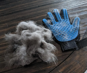 reviewer's photo of the glove next to a giant ball of fur they removed from their cat