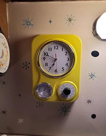 Wall timepiece  with a agleam  framework  featuring a thermometer and a timer, mounted successful  a retro-style room  setting