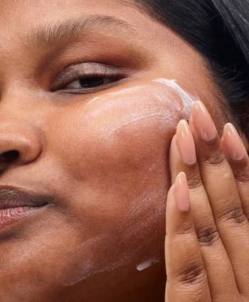 Model applying the moisturizer to their face