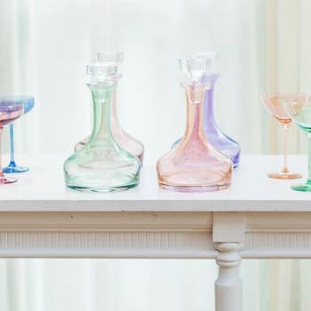 Elegant glassware including decanters and stemmed glasses displayed on a white railing
