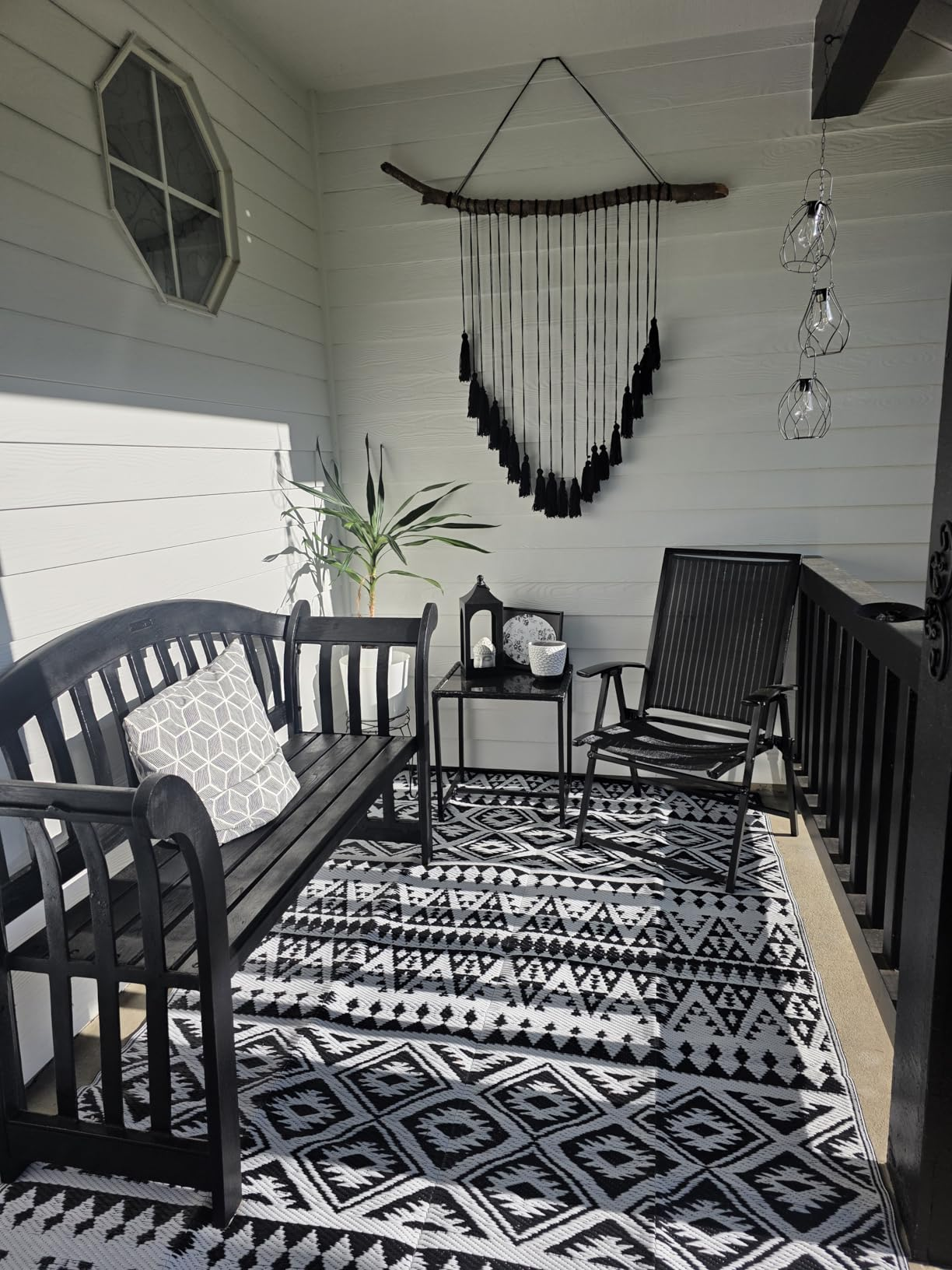 Chic structure  setup with achromatic  bench, geometric pillow, matching chair, and decorative rug. Ideal for outdoor decor inspiration