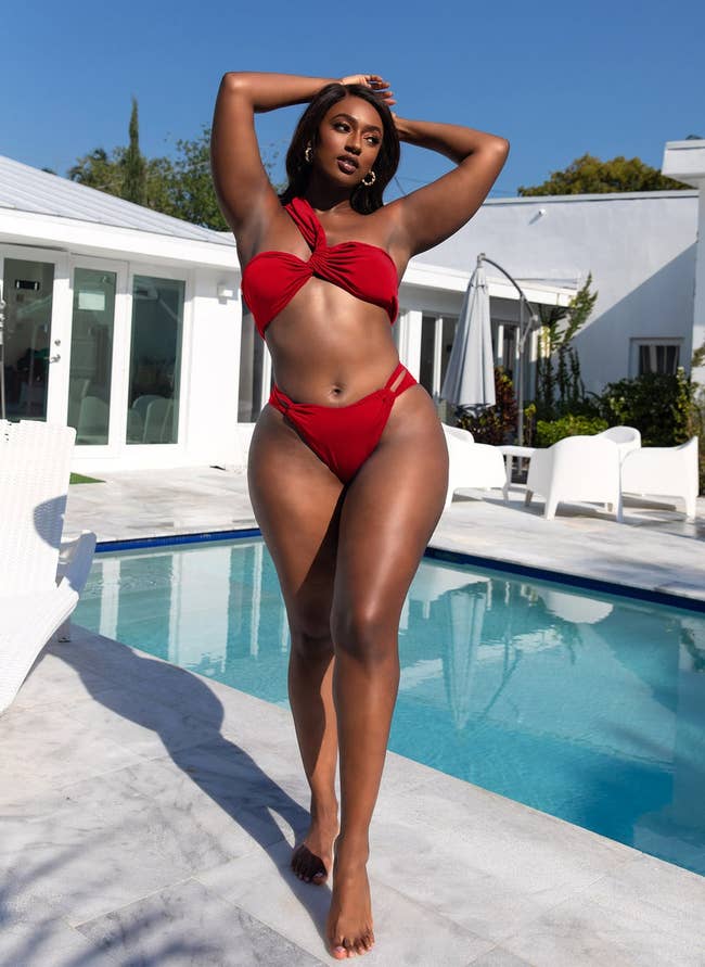 model posing in red bikini by a pool