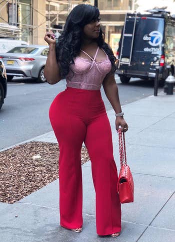 reviewer wearing the pants in red with a lace bustier top 