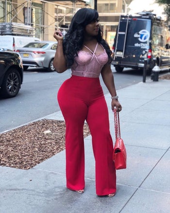 reviewer wearing the pants in red with a lace bustier top 