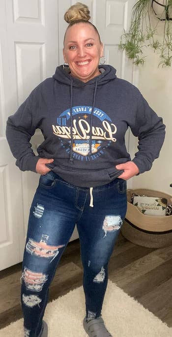 A reviewer smiling, wearing a hoodie with