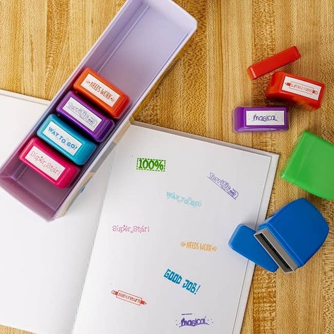 Open notebook with colorful stamps of encouraging phrases similar