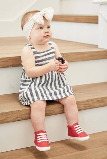 a baby in red sneakers