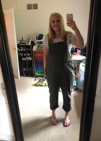 reviewer wearing overalls over a striped t-shirt in mirror selfie
