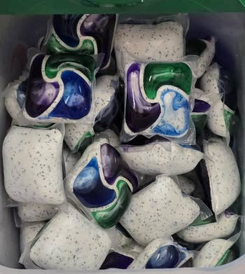 A instrumentality filled with laundry detergent pods, each with a premix of swirled liquid and pulverization sections