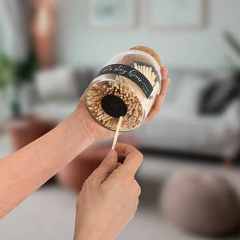 Hands holding a jar of safety matches with a striking surface