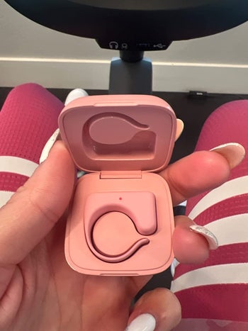 a review holding up the pink remote in its case