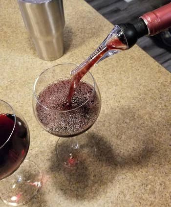 Reviewer pouring out of the wine aerator into a wine glass