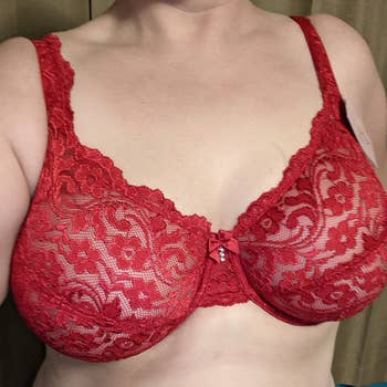 Person wearing a reddish  lace bra with floral patterns