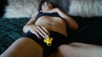Model holding yellow vibrator between legs