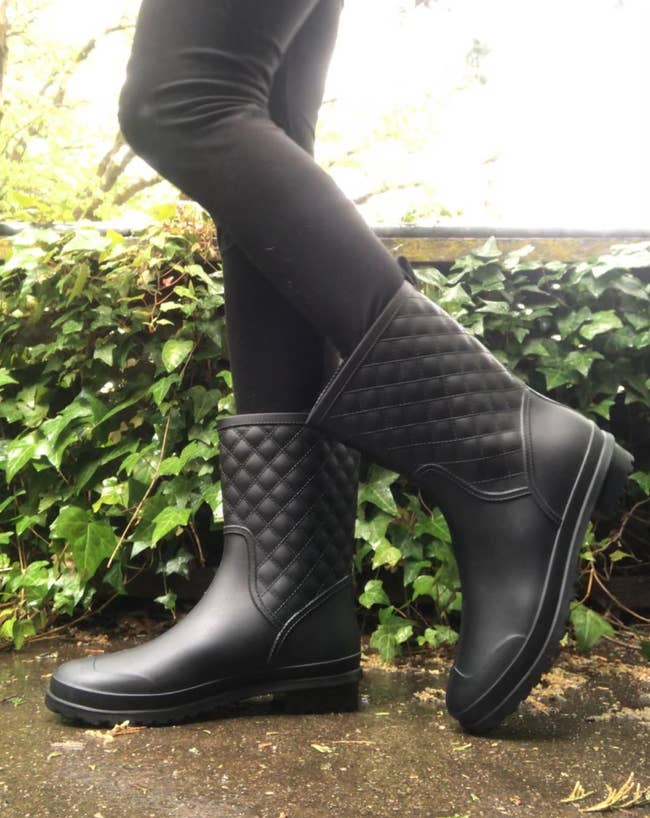 a reviewer in black waterproof boots