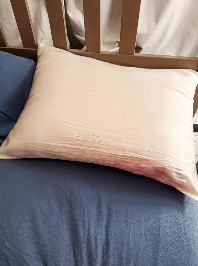 Silk pillowcase on a bed with a wooden headboard, emphasizing luxury bedding choices in a shopping context