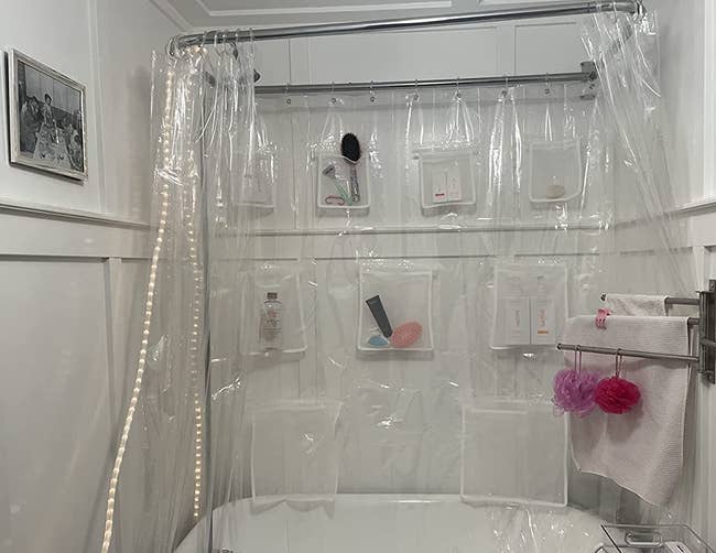 reviewer photo showing the shower curtain with bath products in the pockets 