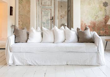 a sofa covered in a white linen cover