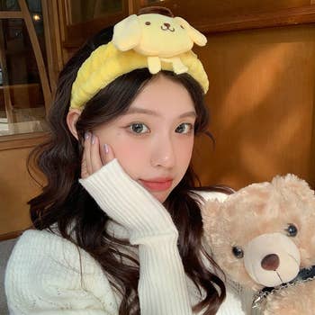 model wears fluffy headband with sanrio dog wearing beret (Pompompurin) 