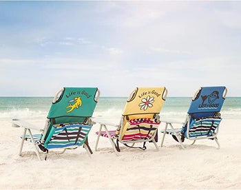 three life is good beach chairs in green, yellow, and blue getting splashed at the shoreline