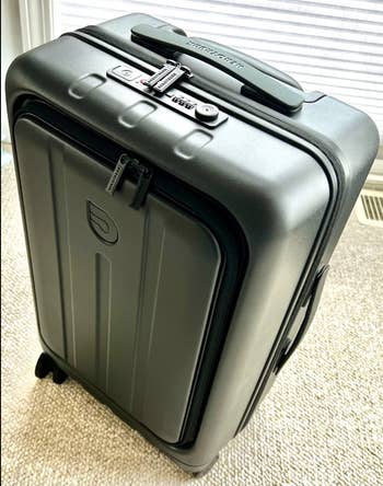 Upright hard-shell suitcase with telescoping handle and wheels,