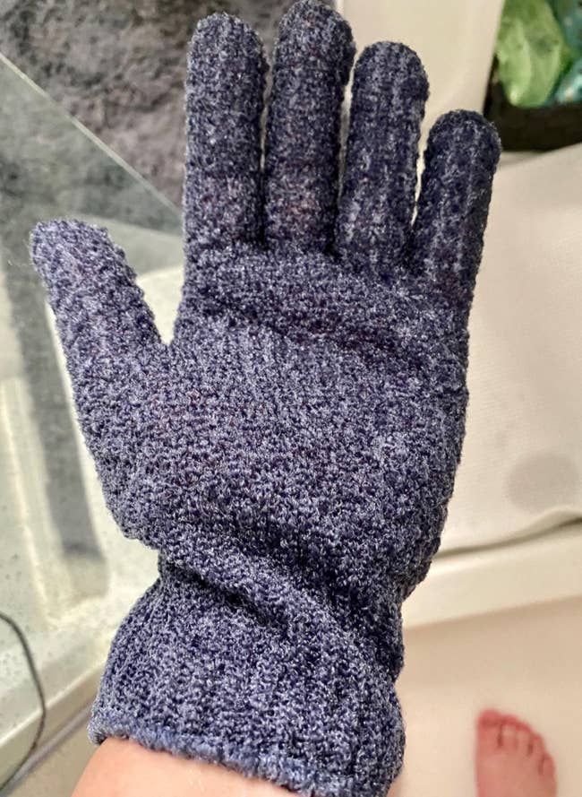 Reviewer wearing blue fingered glove in the shower 