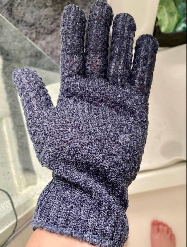 Reviewer wearing blue fingered glove in the shower 