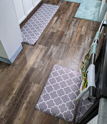 the gray and white kitchen mats in two different sizes in a reviewer's kitchen