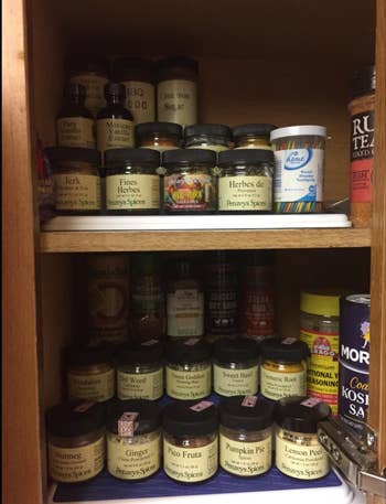 A reviewer's spices organized on the rack in a cabinet 