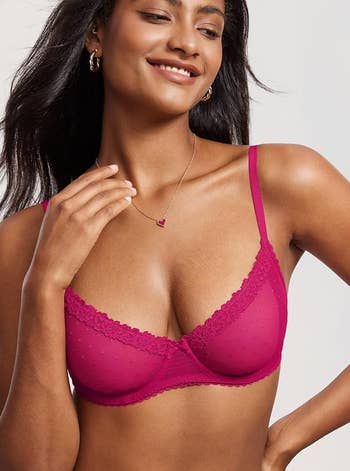 Woman wearing a stylish lace bra smiles, showcasing jewelry