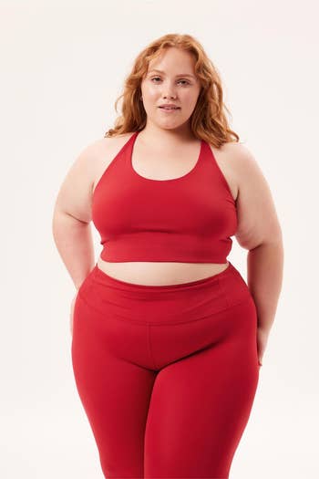 plus-size model wearing a matching red sports bra and leggings