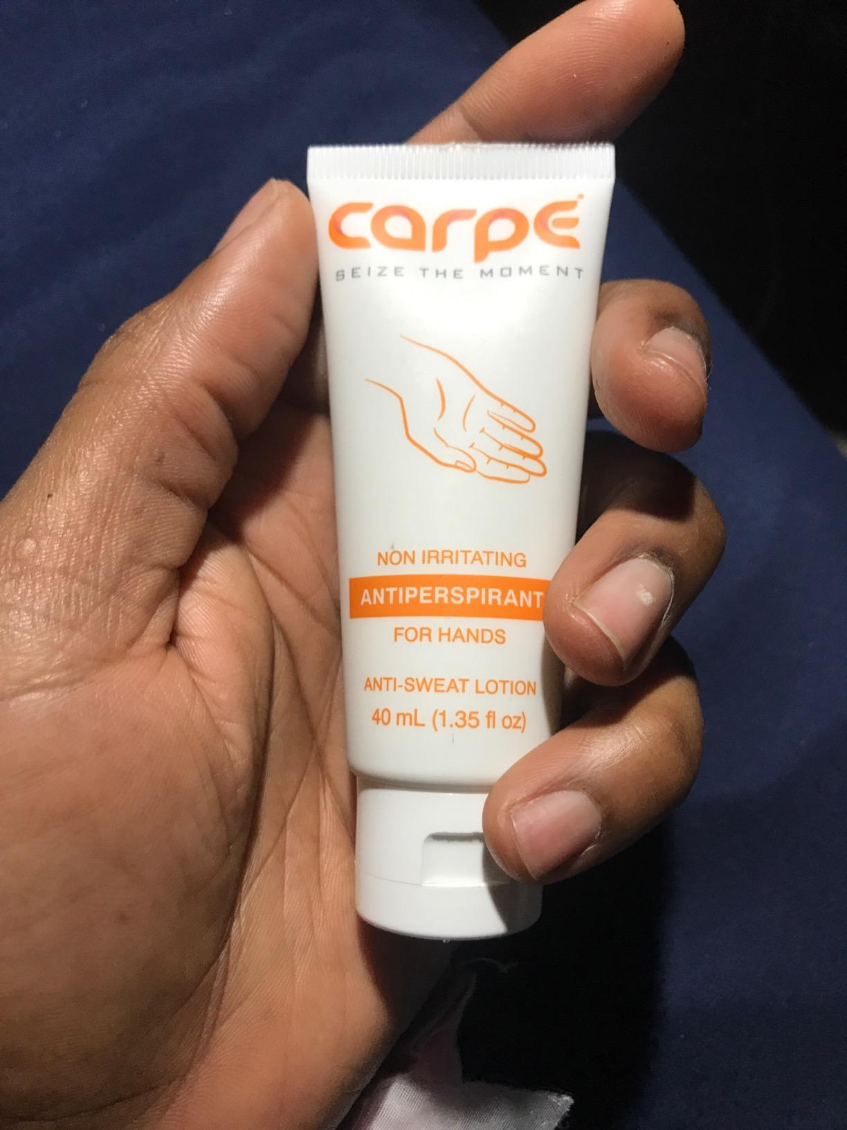 Hand holding a conduit  of Carpe antiperspirant for hands with substance   