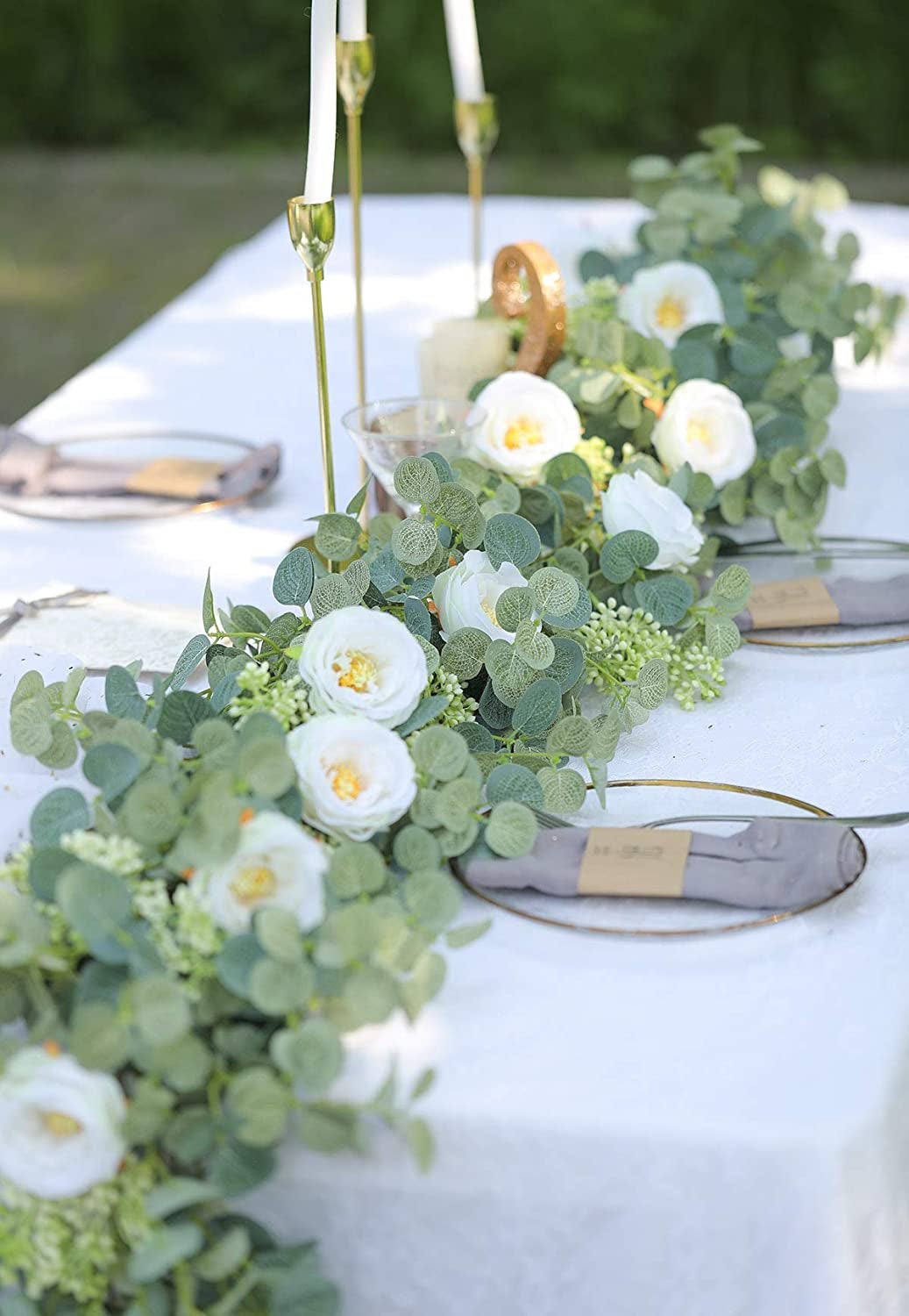 Green and white eucalyptus garland set up on a white table outside
