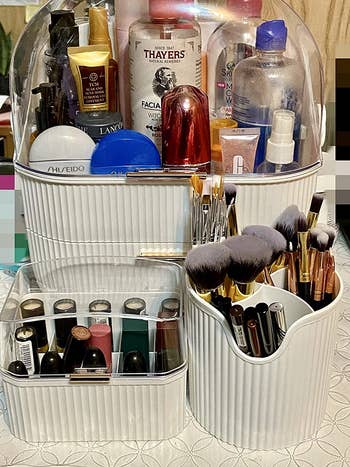 reviewer photo of the full three-piece makeup organizer set full of their cosmetics