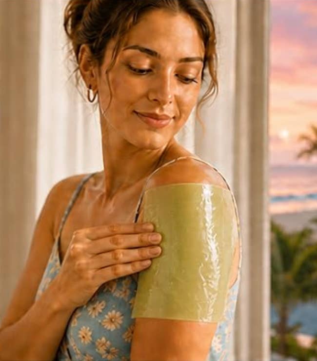 Person with hairsbreadth pulled backmost applies a skincare gel spot to their shoulder, wearing a floral-patterned formal adjacent a model with a scenic view