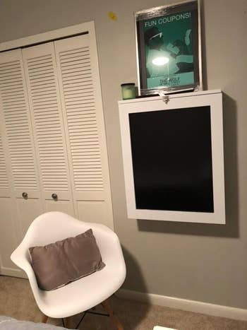 The desk in the color White, folded up into its wall cabinet