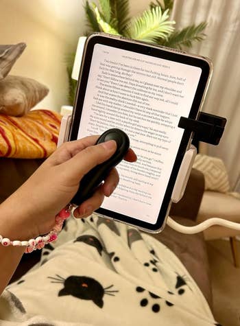 reviewer using the remote while reading in bed