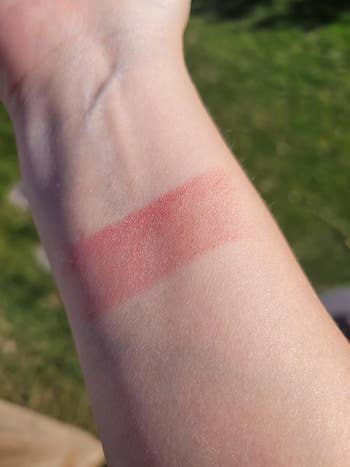 a reviewer showing a peony colored shimmer shadiness  of the multi stick