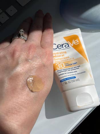 Reviewer with Cerave spf swatch connected hand
