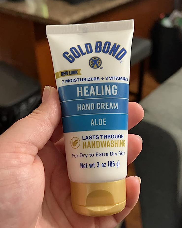A reviewer holding the bottle hand cream