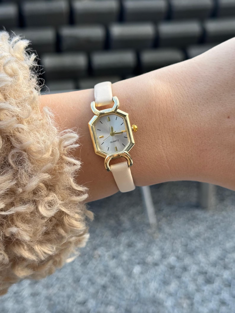 hand wearing the ticker  with a achromatic  leather strap