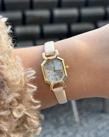 hand wearing the ticker with a achromatic leather strap