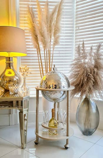 The champagne colored bar cart with a silver disco ball
