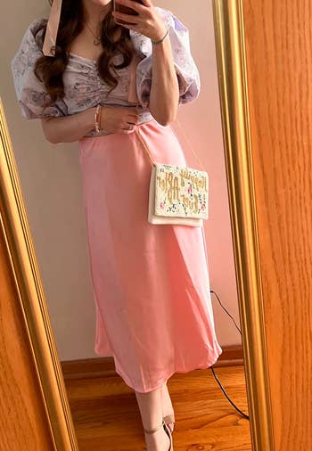 reviewer wearing the pink skirt